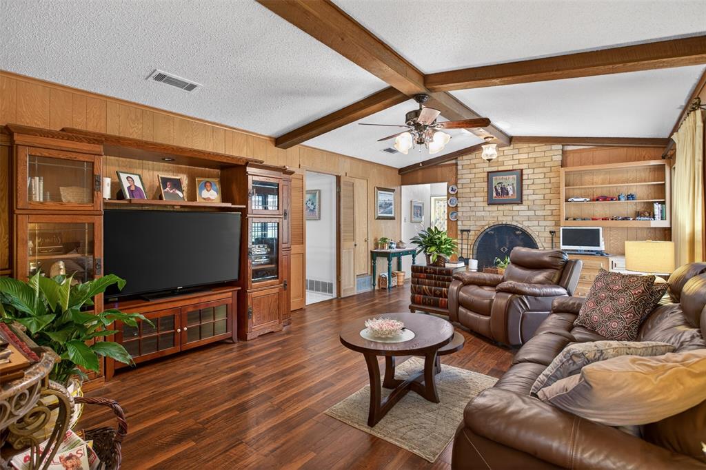 6010 Hunters View Lane Dallas, TX 75232 - Photo 13 of 28 Living area featuring wood-finish flooring and wood paneling