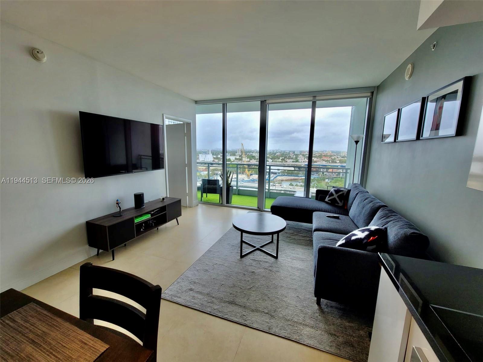 92 Southwest 3rd Street, Unit 1808 Miami, FL 33130 - Photo 2 of 45 a living room with furniture and a flat screen tv