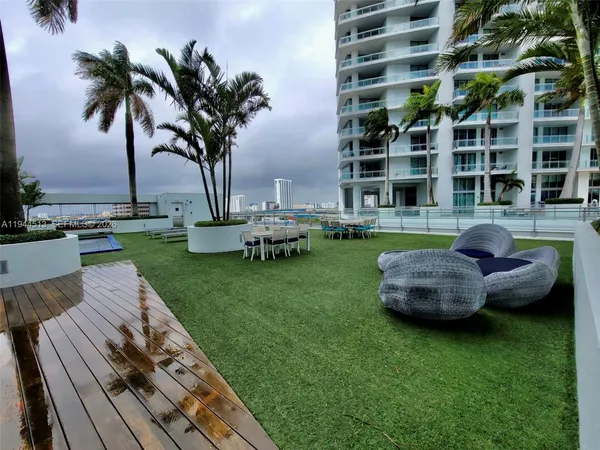a view of a swimming pool with lawn chairs and a yard