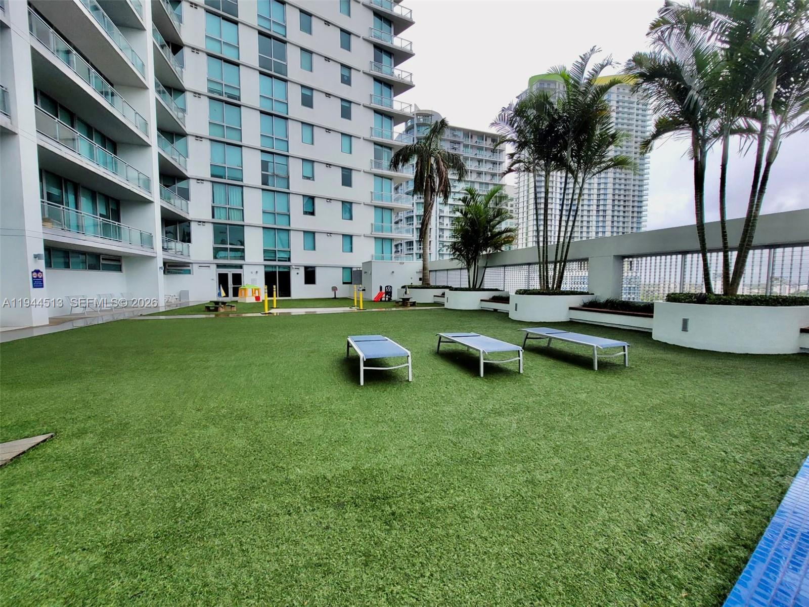 92 Southwest 3rd Street, Unit 1808 Miami, FL 33130 - Photo 29 of 45 a view of a swimming pool with lawn chairs and a yard