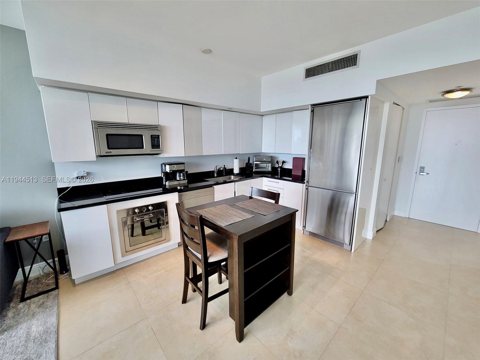 92 Southwest 3rd Street, Unit 1808 Miami, FL 33130 - Photo 3 of 45 a kitchen with a stove a refrigerator and a sink