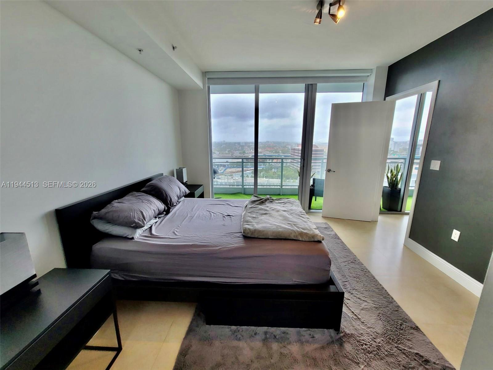 92 Southwest 3rd Street, Unit 1808 Miami, FL 33130 - Photo 4 of 45 a bed sitting in a bedroom next to a window