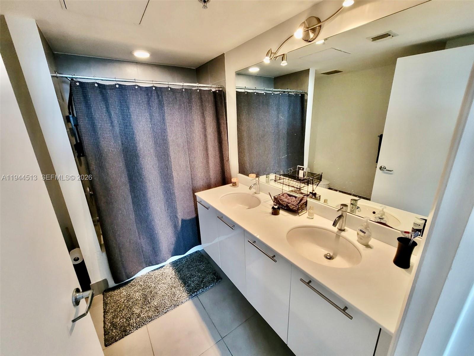 92 Southwest 3rd Street, Unit 1808 Miami, FL 33130 - Photo 5 of 45 a bathroom with a sink and mirror