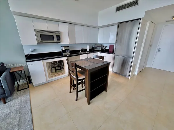 a kitchen with a stove a refrigerator and a microwave