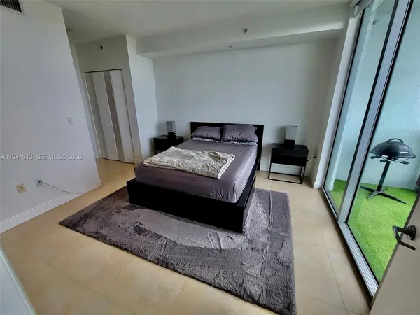 a bedroom with a bed and a mirror on dresser