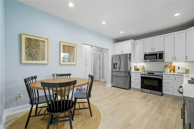 a kitchen with stainless steel appliances a refrigerator stove microwave and white cabinets