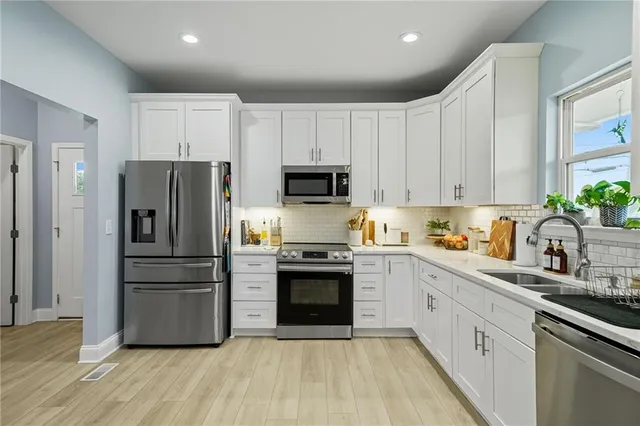 a kitchen with stainless steel appliances a refrigerator sink and microwave