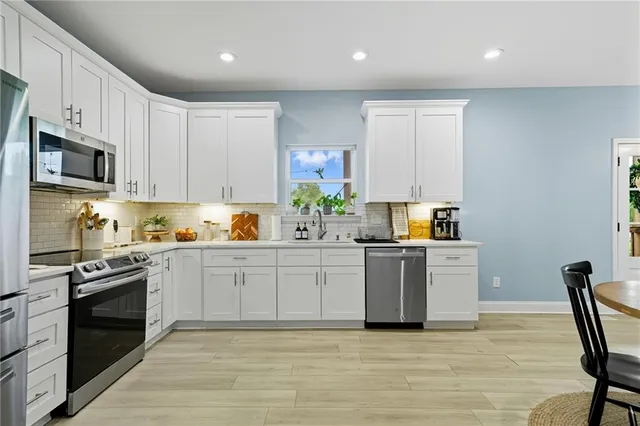 a kitchen with stainless steel appliances granite countertop a stove a sink dishwasher a microwave oven and a refrigerator