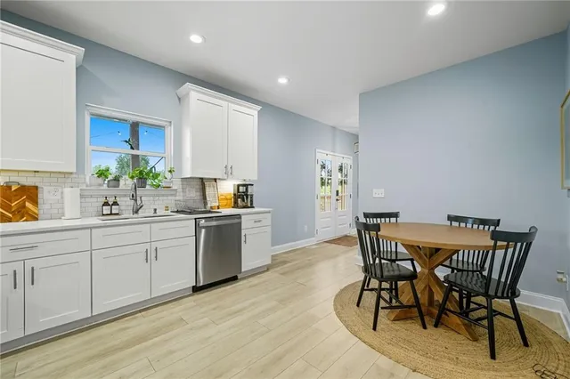 a kitchen with granite countertop white cabinets and stainless steel appliances