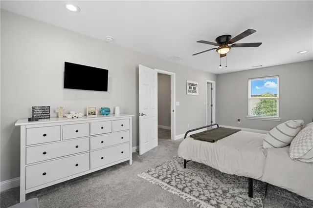 a bedroom with a bed a window and a flat screen television