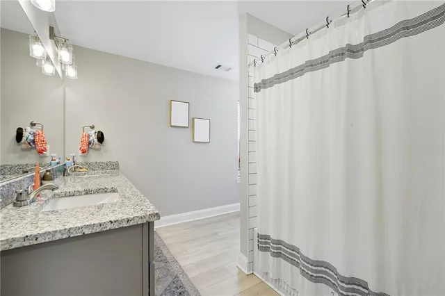 a bathroom with a granite countertop sink and a mirror