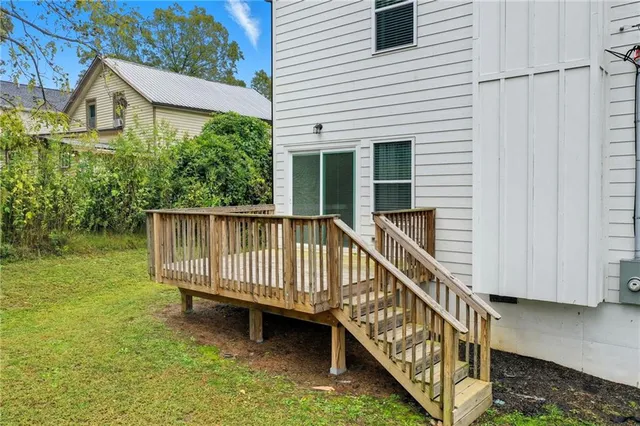 a view of a house with wooden deck and a floor to ceiling window