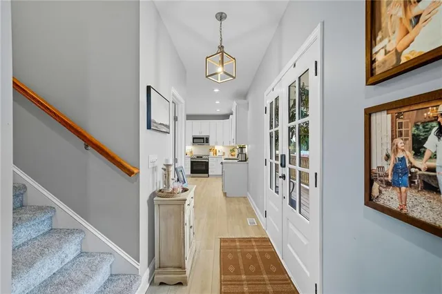 a view of a hallway with wooden floor and staircase