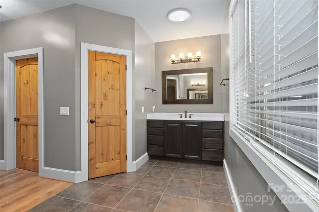 a bathroom with a double vanity sink a mirror and a bathtub