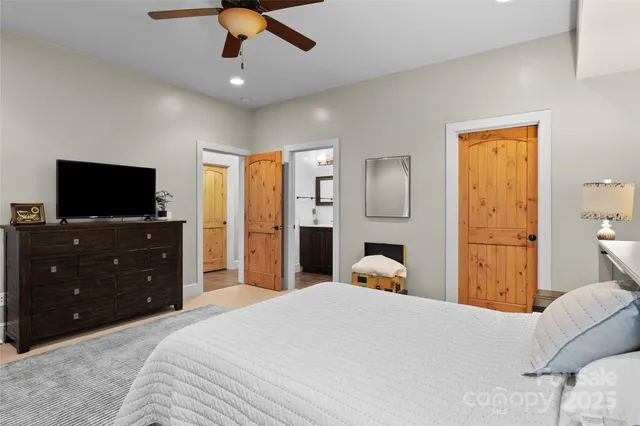 a bedroom with a bed and a flat tv screen on dresser