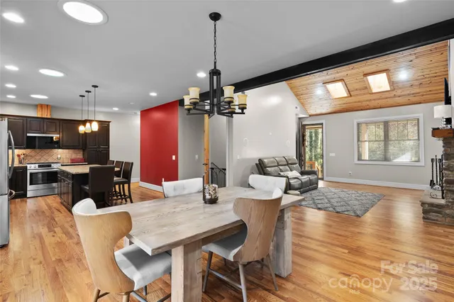 a dining room with furniture a chandelier and wooden floor