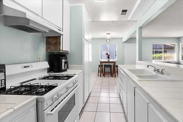 a kitchen with a sink a stove and cabinets