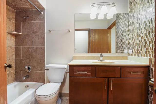 a bathroom with a granite countertop sink a toilet and shower