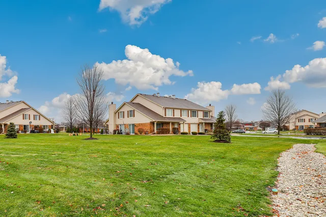 a view of a big house with a big yard and large trees
