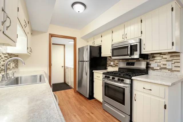 a kitchen with granite countertop a sink a stove and refrigerator
