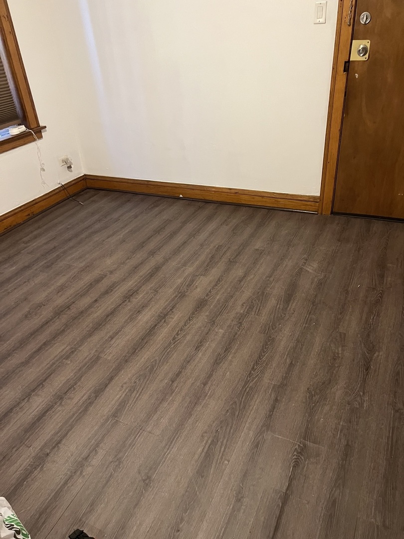 6837 South Maplewood Avenue, Unit 1R Chicago, IL 60629 - Photo 3 of 16 a view of an empty room with wooden floor and a window