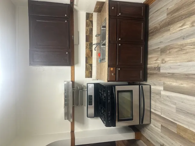 a kitchen with wooden floor and a stainless steel appliances