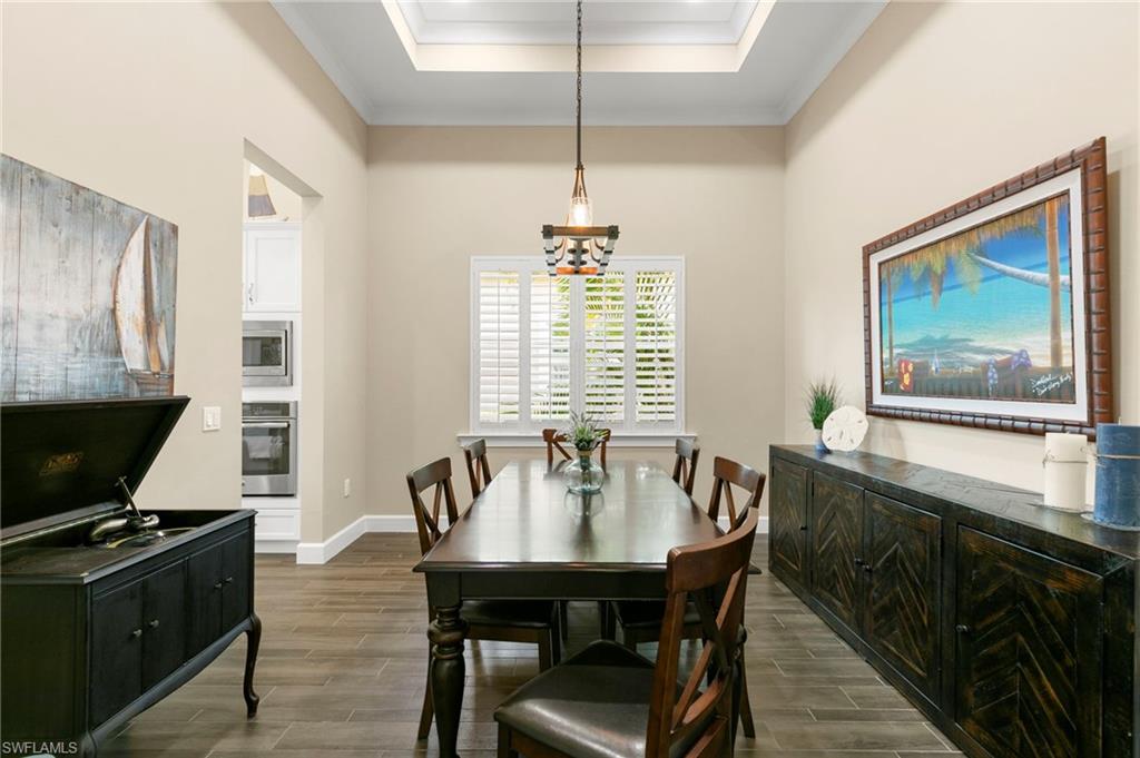4922 Andros Drive Naples, FL 34113 - Photo 11 of 44 a view of a dining room with furniture window and wooden floor