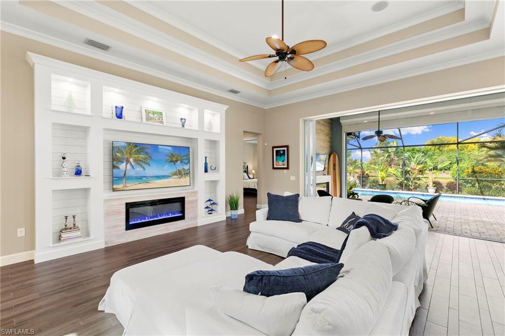 4922 Andros Drive Naples, FL 34113 - Photo 13 of 44 a living room with furniture a fireplace and a flat screen tv