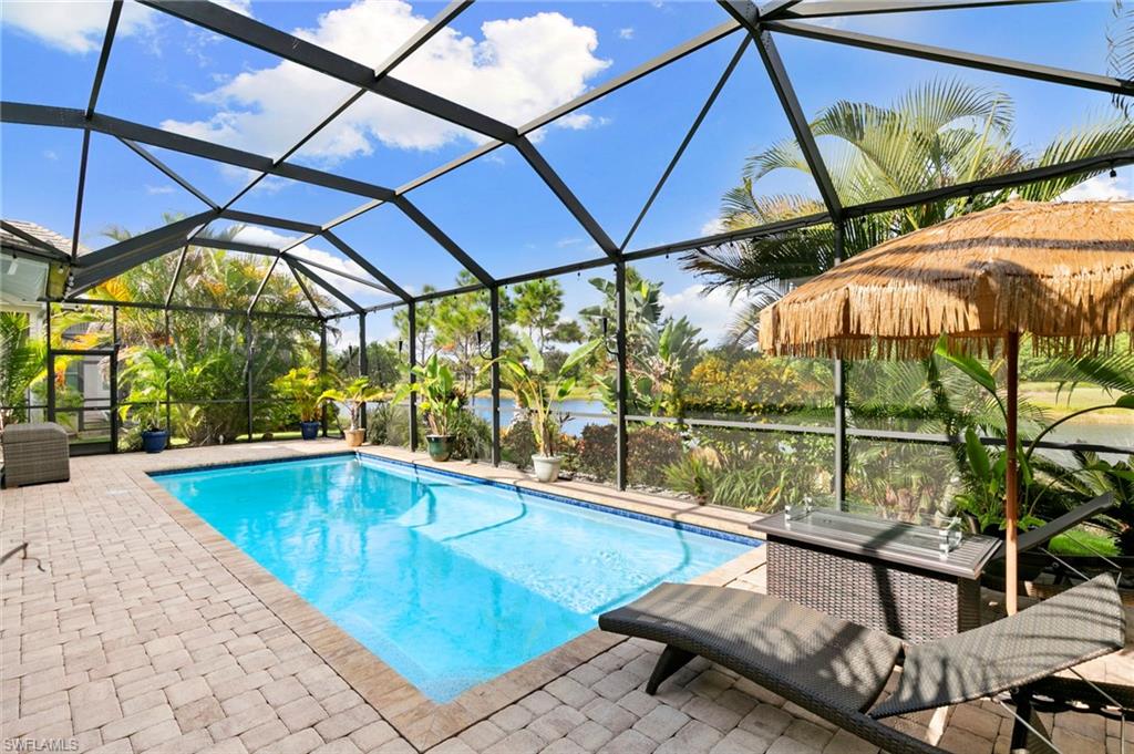 4922 Andros Drive Naples, FL 34113 - Photo 17 of 44 an outdoor patio with swimming pool table and chairs