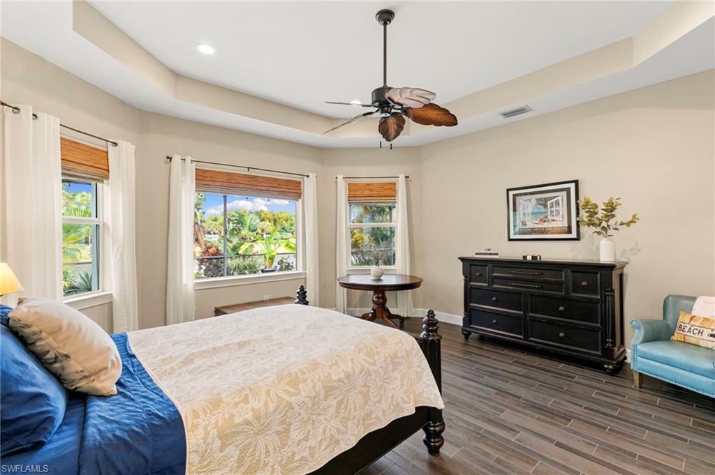 4922 Andros Drive Naples, FL 34113 - Photo 23 of 44 a bedroom with a bed and wooden floor