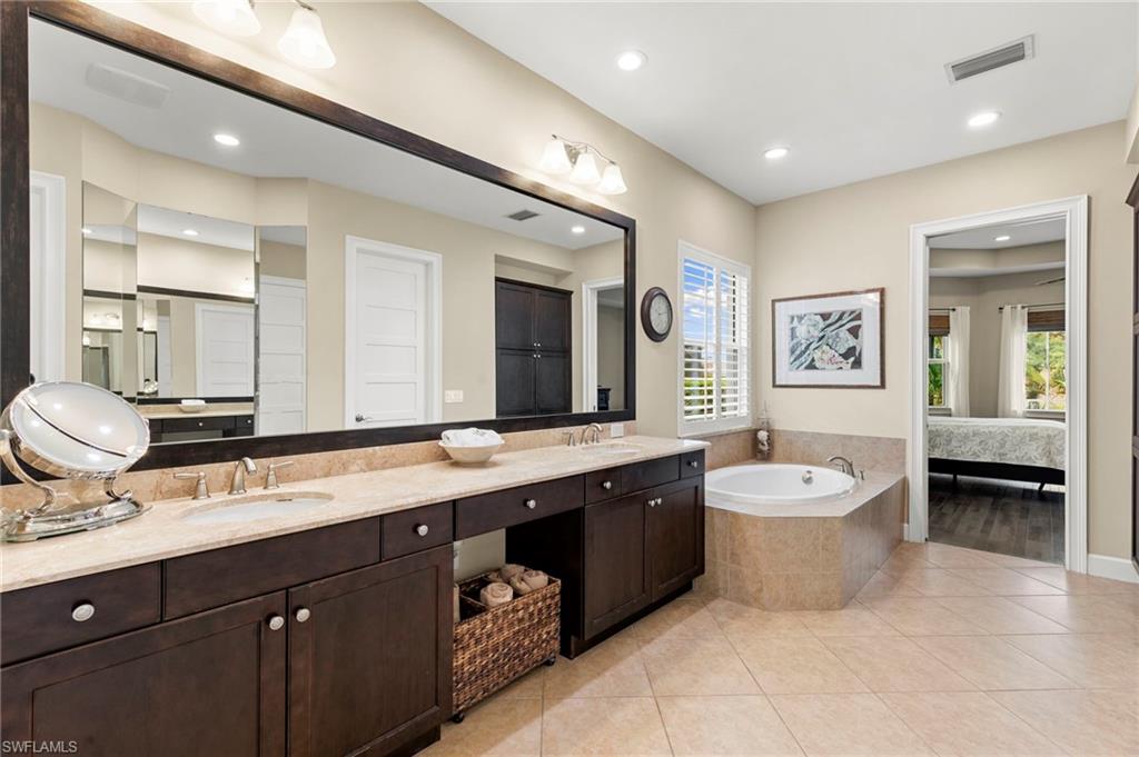 4922 Andros Drive Naples, FL 34113 - Photo 25 of 44 a spacious bathroom with a double vanity sink mirror and bathtub