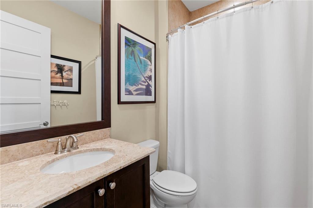 4922 Andros Drive Naples, FL 34113 - Photo 27 of 44 a bathroom with a granite countertop sink toilet and a mirror