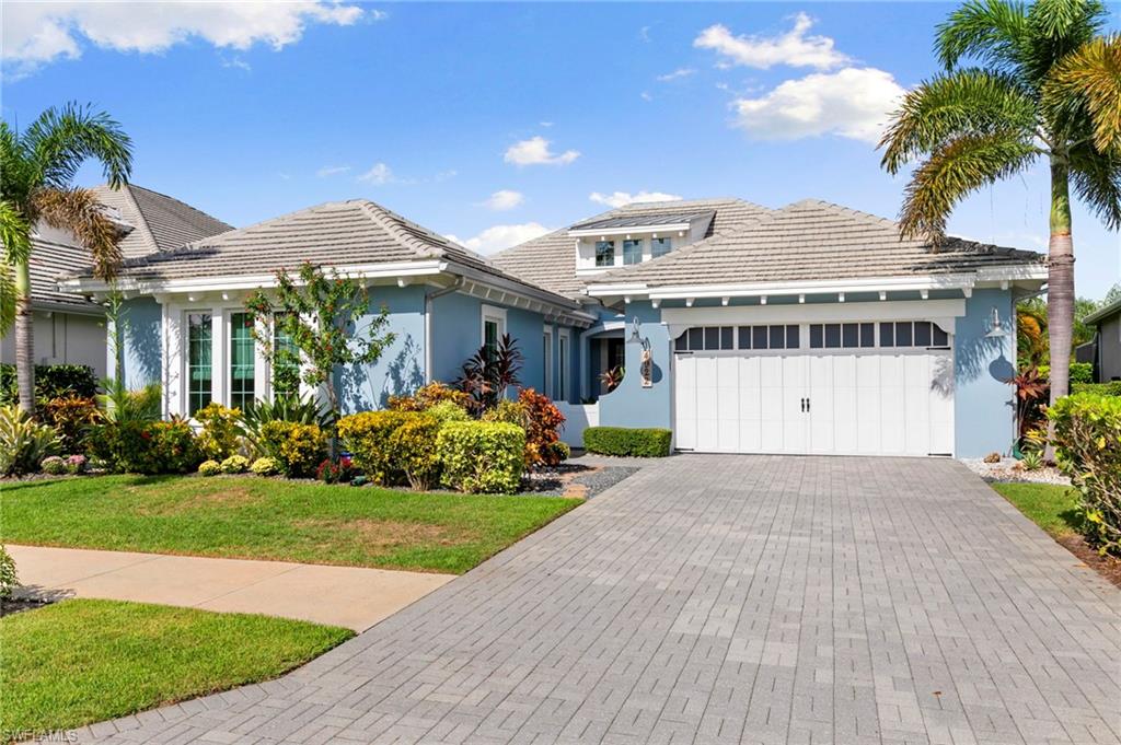 4922 Andros Drive Naples, FL 34113 - Photo 3 of 44 a front view of a house with a garden and yard