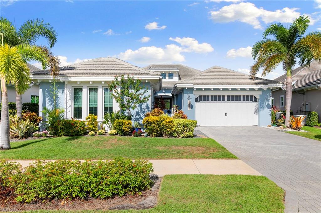 4922 Andros Drive Naples, FL 34113 - Photo 34 of 44 a front view of a house with a yard and potted plants