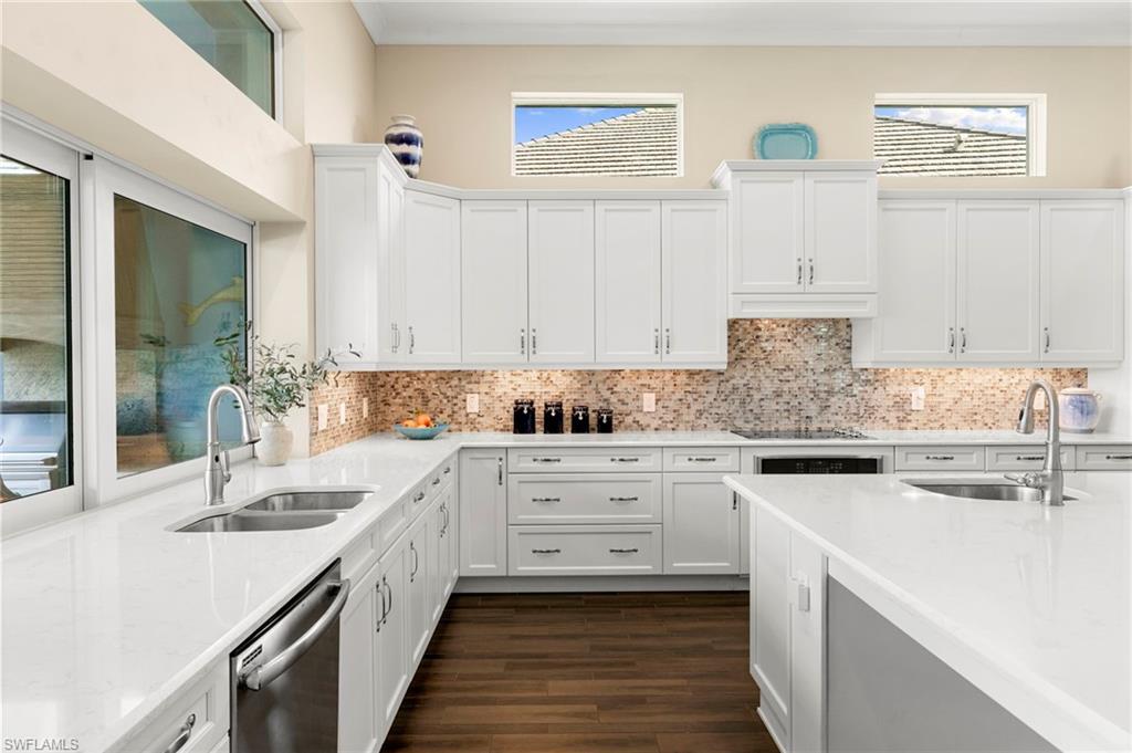 4922 Andros Drive Naples, FL 34113 - Photo 5 of 44 a kitchen with stainless steel appliances white cabinets sink and wooden floor