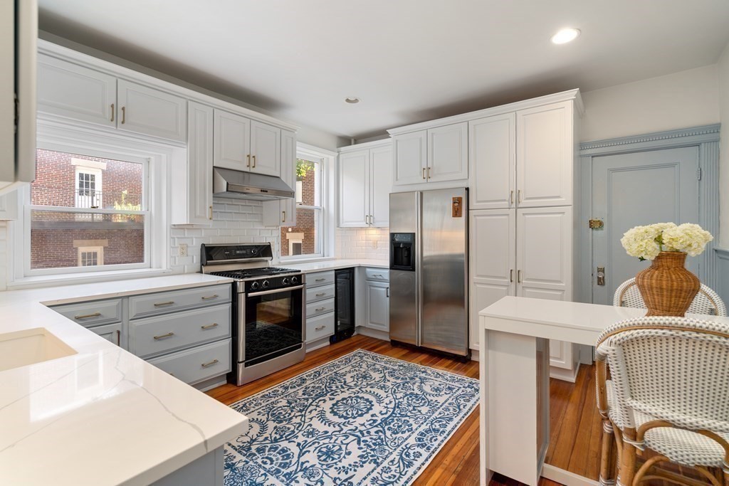 89 Mason Terrace, Unit 3 Brookline, MA 02446 - Photo 13 of 19 a kitchen with stainless steel appliances granite countertop a refrigerator stove microwave and sink