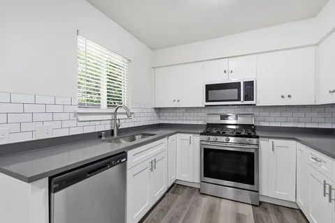 a kitchen with stainless steel appliances a stove sink and microwave