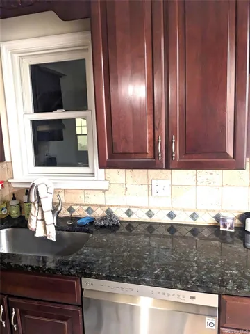 a kitchen with granite countertop cabinets and window