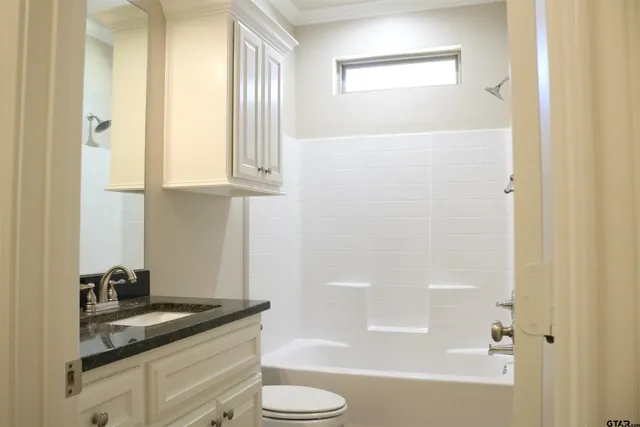 a bathroom with a granite countertop sink toilet and bathtub