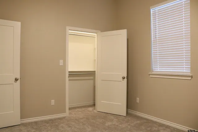 an empty room with windows and closet