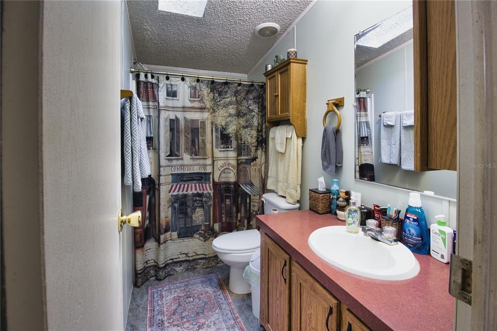 2498 Saturn Road Brooksville, FL 34604 - Photo 18 of 26 a bathroom with a sink vanity mirror and toilet