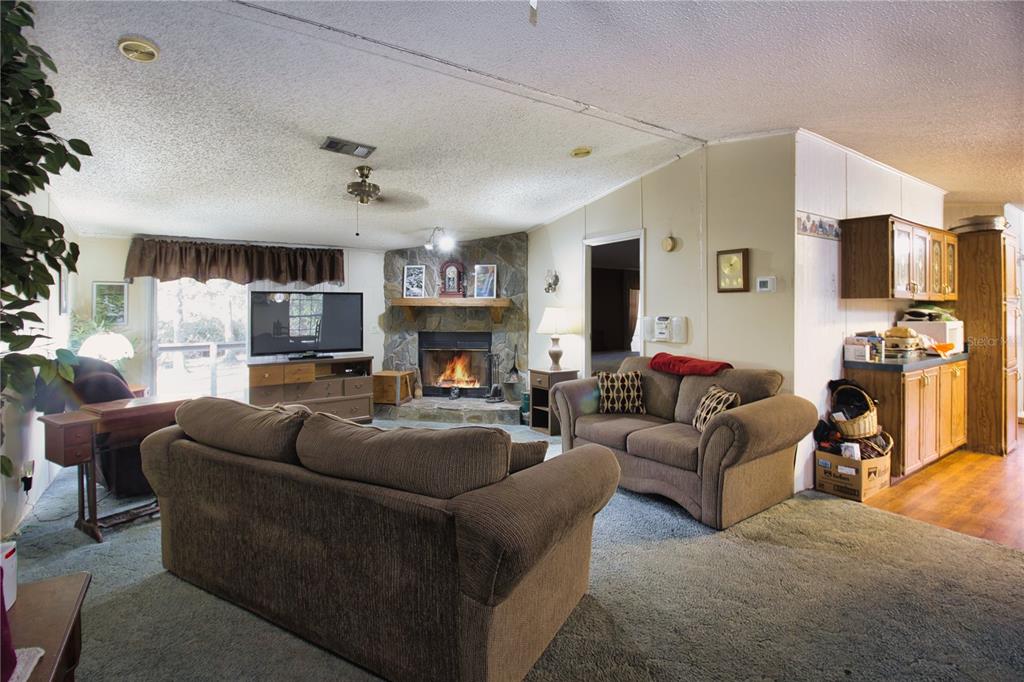 2498 Saturn Road Brooksville, FL 34604 - Photo 4 of 26 a living room with furniture a fireplace and a flat screen tv
