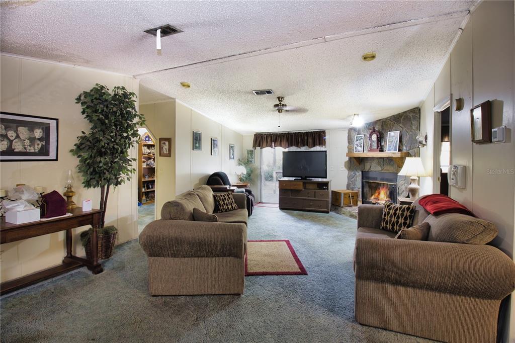 2498 Saturn Road Brooksville, FL 34604 - Photo 5 of 26 a living room with furniture and a fireplace