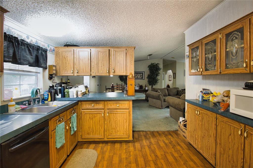 2498 Saturn Road Brooksville, FL 34604 - Photo 7 of 26 a kitchen with stainless steel appliances granite countertop wooden cabinets a sink dishwasher a stove and a refrigerator