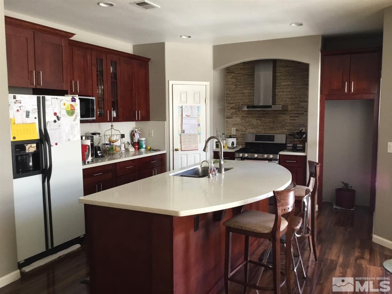 1432 Gaucho Lane Reno, NV 89521 - Photo 4 of 13 a kitchen with stainless steel appliances a table chairs and a refrigerator