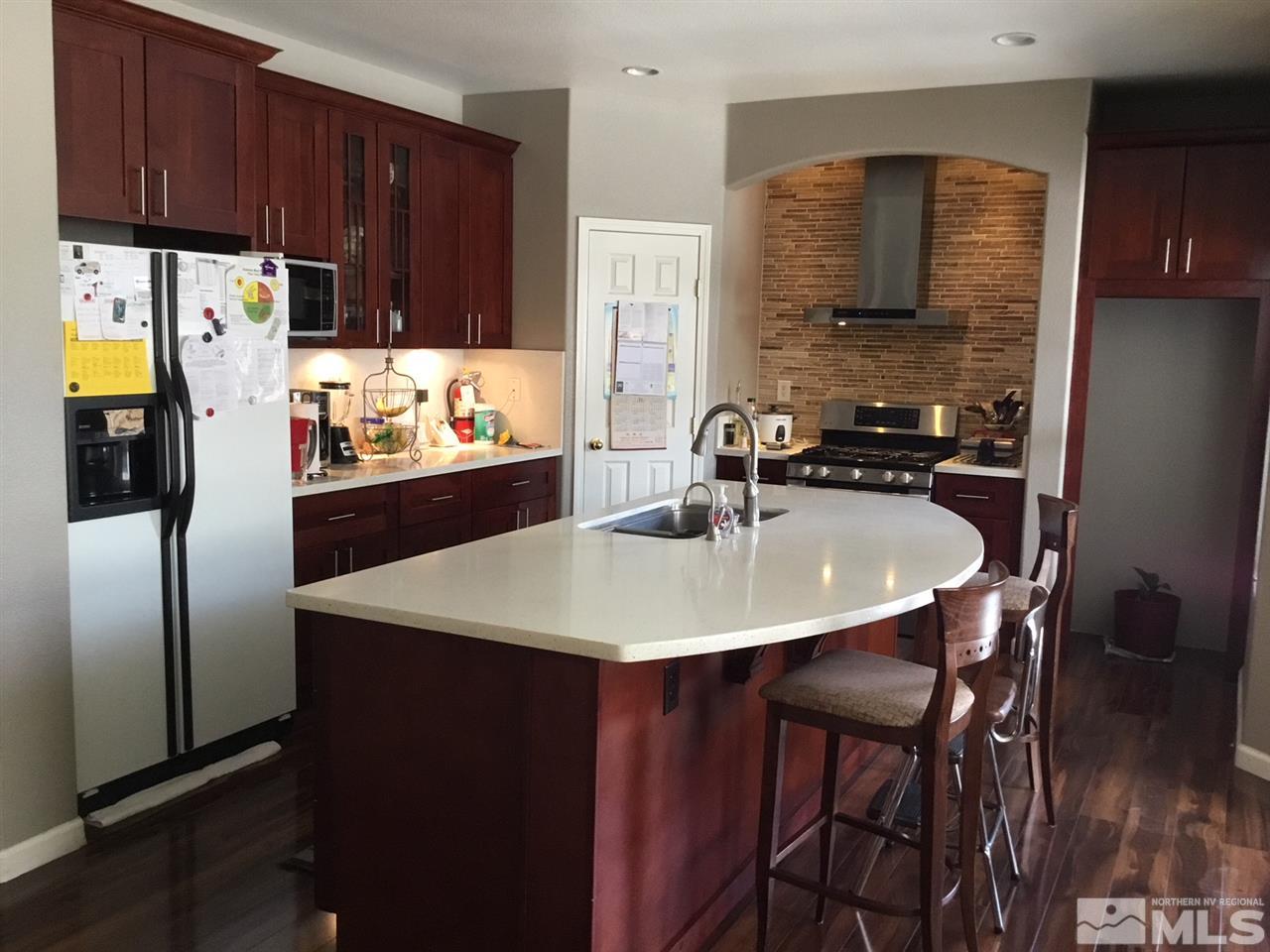 1432 Gaucho Lane Reno, NV 89521 - Photo 7 of 13 a kitchen with stainless steel appliances a sink a stove a refrigerator with a dining table and chairs