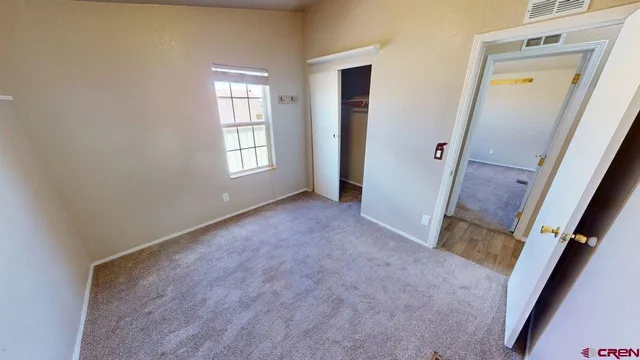 an empty room with windows and hardwood floor