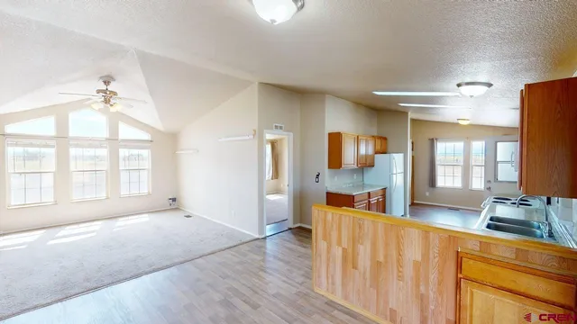 a view of a kitchen with kitchen island granite countertop wooden floor and stainless steel appliances