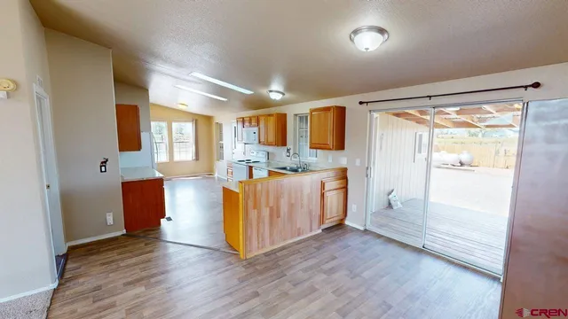a kitchen with kitchen island granite countertop wooden floors and white stainless steel appliances