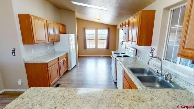 a kitchen with stainless steel appliances granite countertop a sink stove and cabinets
